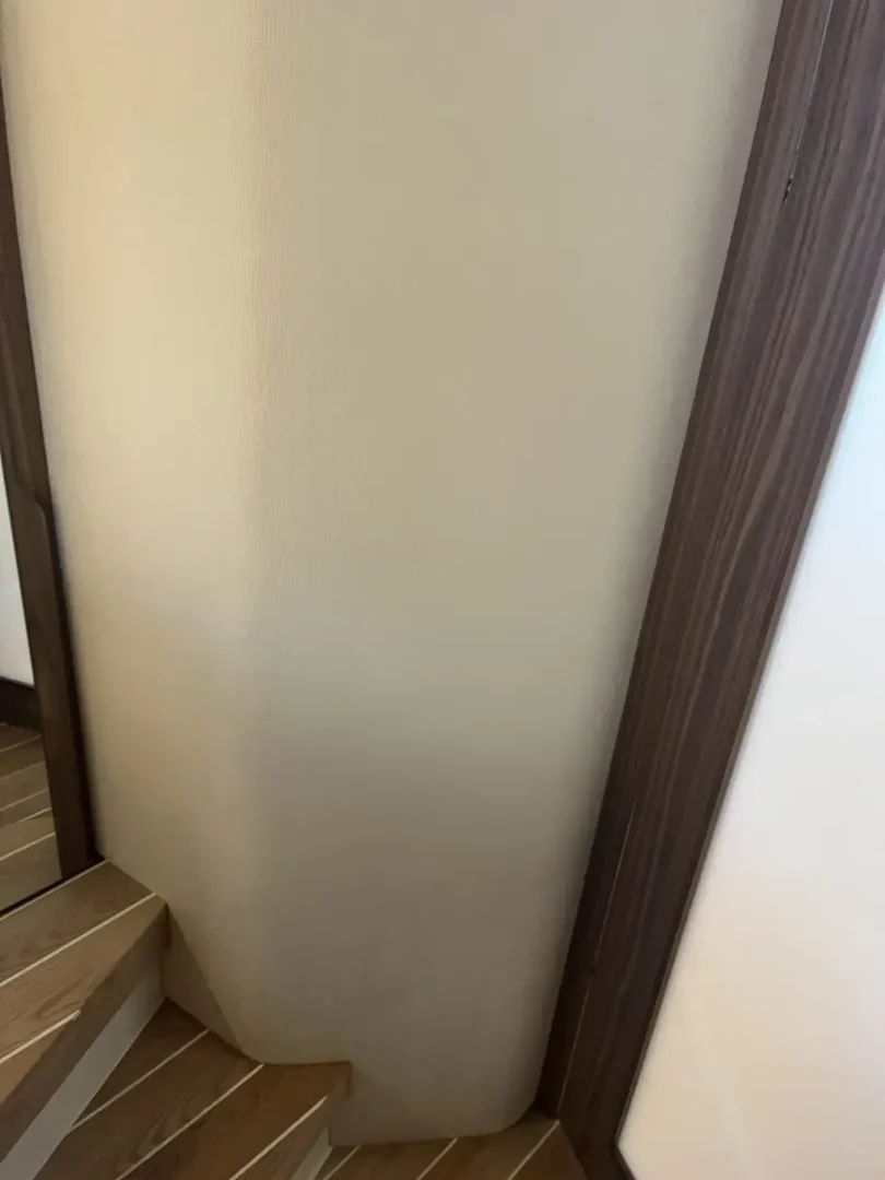 Contact Us Today Close-up of wall near stairs with discoloration and water damage marks.